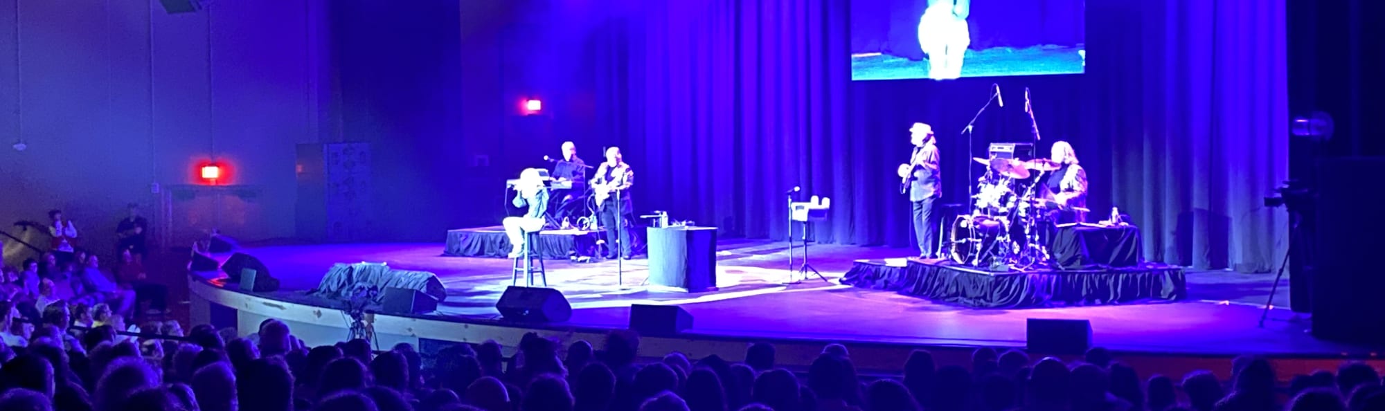 signer on stage in chair washed out by the lights Lafayette